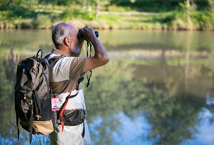 Man using binoculars to observe flora and fauna