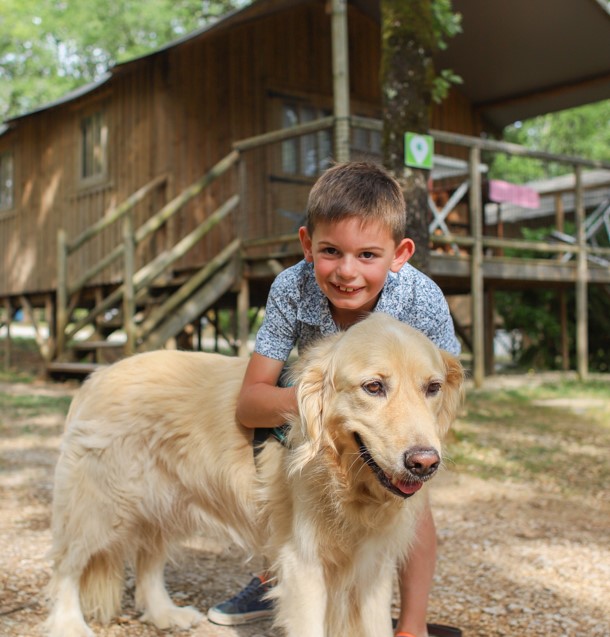 A child with their dog in a campsite