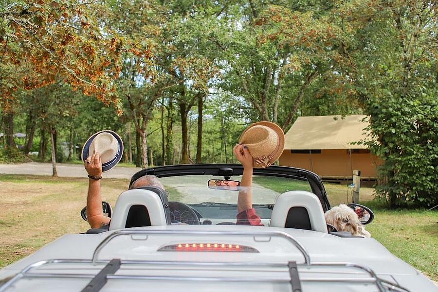 Couple in a convertible enjoying a camping vacation in September