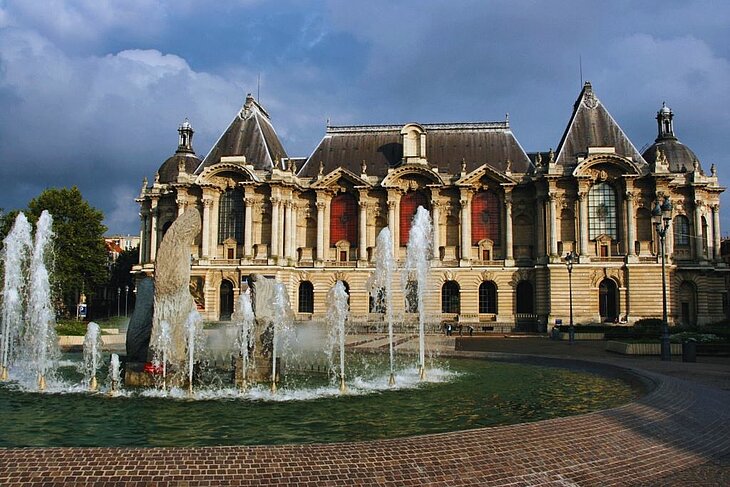 Façade of the Palace of Fine Arts of Lille with a fountain in the foreground, a cultural landmark in the Hauts-de-France region
