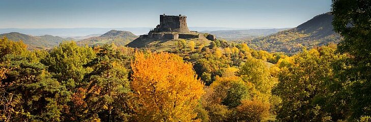 Auvergne landscapes in autumn Castle overlooking wooded hills in autumn colours in Auvergne