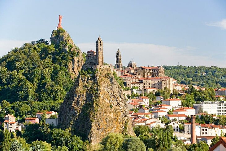 Panoramic view of Le Puy-en-Velay with the Saint-Michel d’Aiguilhe chapel and the Notre-Dame de France statue, a must-see historic site near Sainte-Sigolène