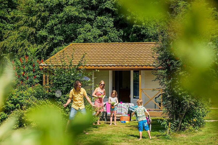 Couple and two children playing in front of their mobile home