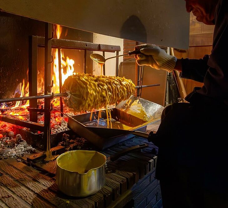 Handcrafted gâteau à la broche baked over a wood fire, a typical activity in Sazos that showcases the sweet traditions of the Pyrenees.