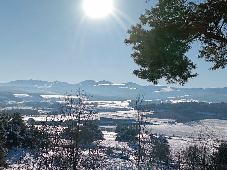 Snow-covered winter landscape with panoramic mountain views under a bright winter sun. A pristine natural setting, perfect for a snow campsite holiday with Sites et Paysages.