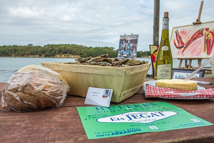 Tasting local specialities in Arradon, with fresh oysters, cheese, traditional bread and Muscadet – a gourmet break recommended by Philippe, the campsite owner.