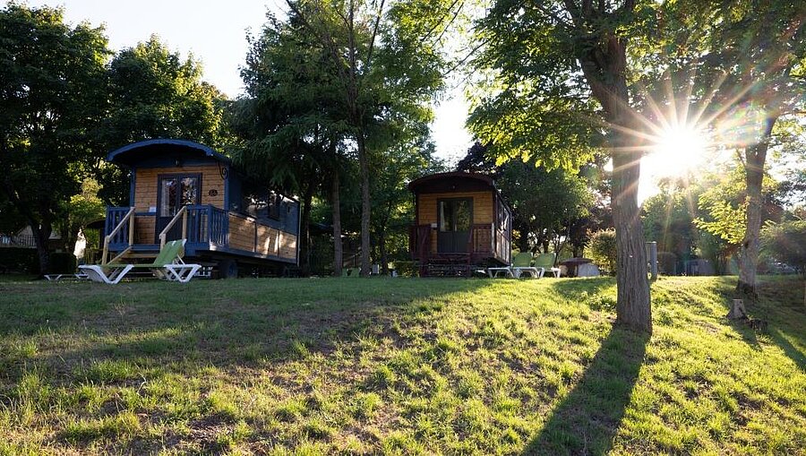 Wooden gypsy wagons at Gien tourist campsite, an unusual rental near Orléans in a peaceful green environment.