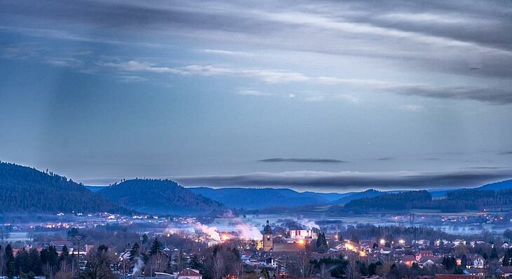 View of Corcieux at dusk, nestled among the Vosges hills — a perfect blend of nature and heritage tourism.