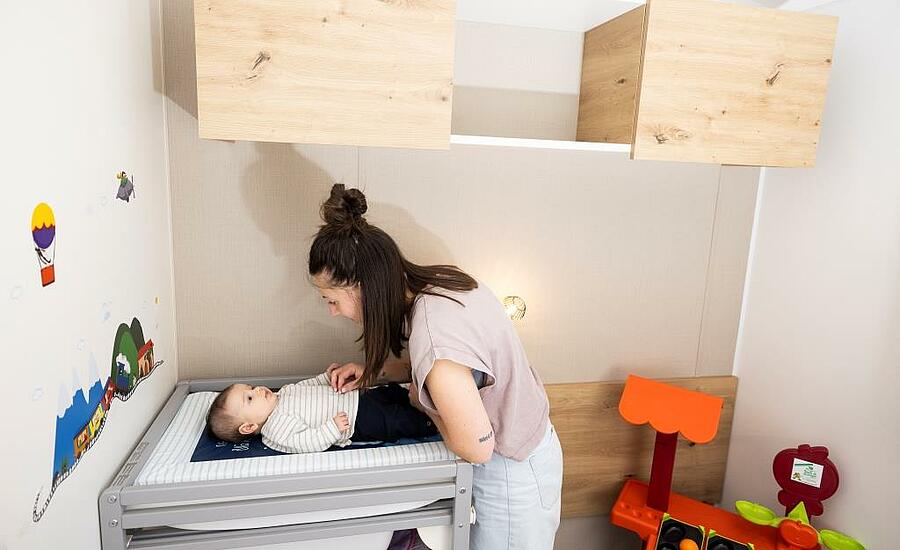 Mum changing her baby in camping accommodation