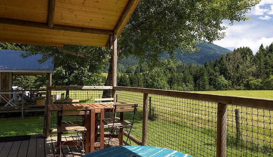 Covered wooden terrace in a campsite in Isère, facing the Alps in a peaceful natural setting