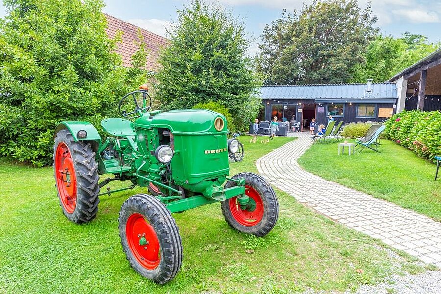 Vintage green tractor on the lawn of a friendly campsite near Concarneau, peaceful family atmosphere in Brittany.
