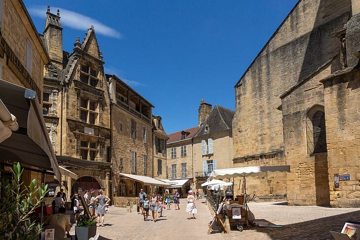 Lively square in Sarlat-la-Canéda with cobbled streets and stone façades, a must-see characterful village in the Dordogne.