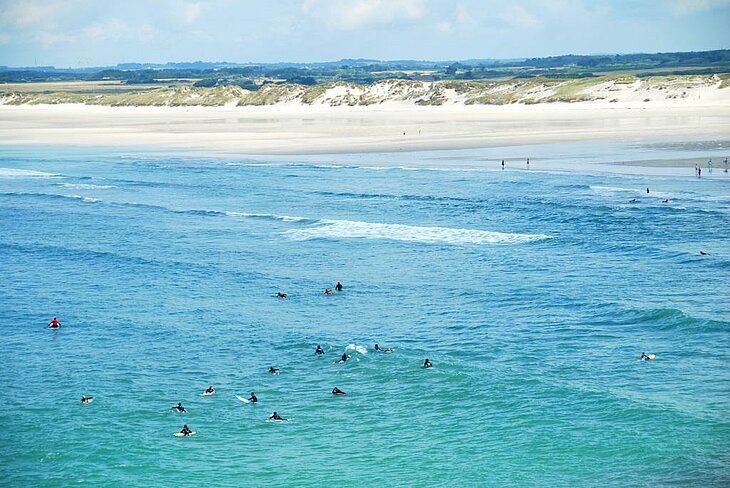 Surfers at Pointe de la Torche in Plomeur, one of Brittany’s most famous spots for board sports and outdoor adventure tourism.