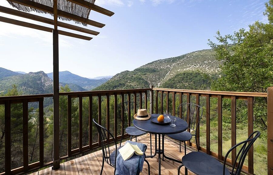 Wooden terrace of a campsite accommodation in the Drôme with panoramic views of the lush hills