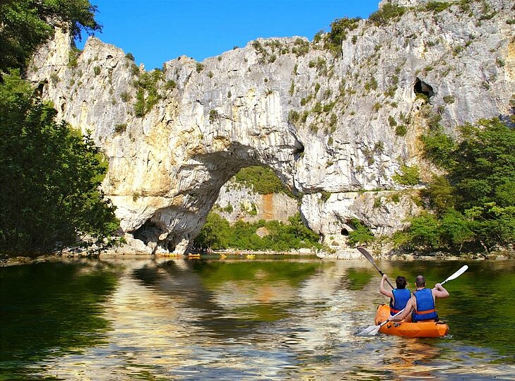 Canoe trip under the Pont d’Arc in Ardèche, a landmark site in Auvergne-Rhône-Alpes, perfect for white-water sports fans and stunning landscapes