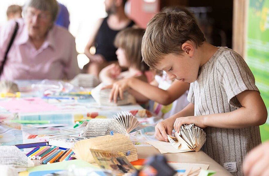 Children focused on a creative workshop at a campsite kids’ club, supervised entertainment designed for fun and creativity.
