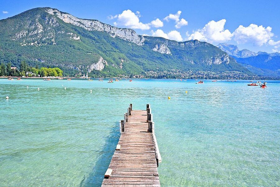 Wooden dock on Lake Annecy with turquoise water and mountain backdrop