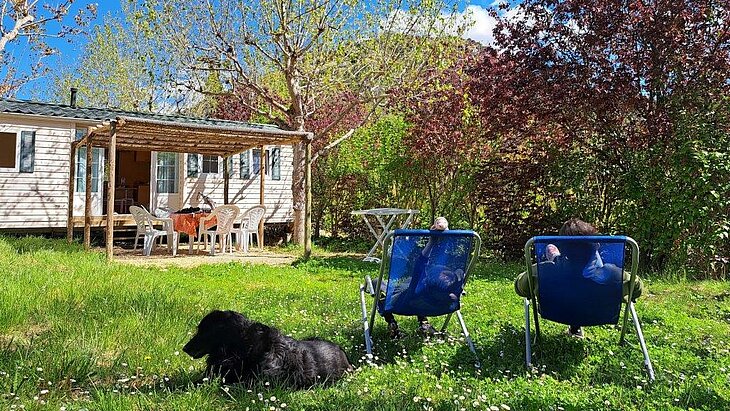 A Peaceful Stay at Domaine de l’Écluse in the Drôme Holidaymakers relaxing with their dog outside a mobile home with a terrace at Domaine de l’Écluse in the Drôme.