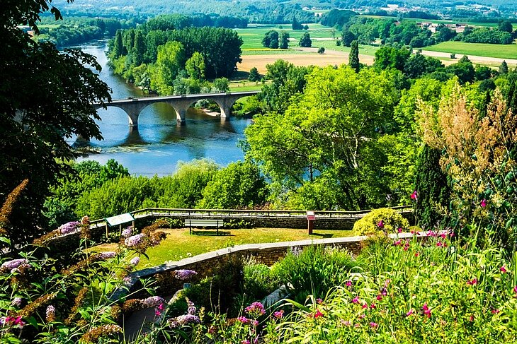 Limeuil and the Vézère View of Limeuil and the valley, featuring the Vézère River, a stone bridge and an elevated garden in the Dordogne.