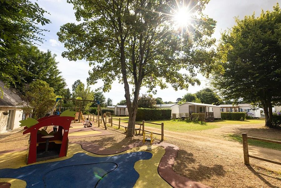 Playground and mobile homes at Le Neptune campsite in Lanloup, a family campsite near Saint-Brieuc, ideal for children.