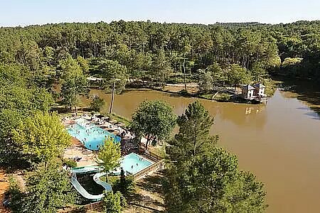Aerial view of the Domaine de l'Etang de Bazange campsite, with pool and slide by the lake, in the heart of a forest