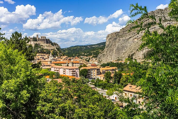 Panoramic view of Sisteron with its famous citadel overlooking the town and limestone cliffs, a must-see site to explore Sisteron's history and heritage through cultural and tourist activities.
