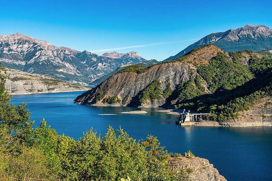 View of Lake Serre-Ponçon surrounded by mountains near Gap, an iconic landscape to explore during a camping holiday near Gap.