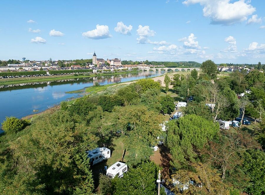 Aerial view of a campsite by the Loire River near Orléans, at Gien tourist campsite, green pitches surrounded by nature.