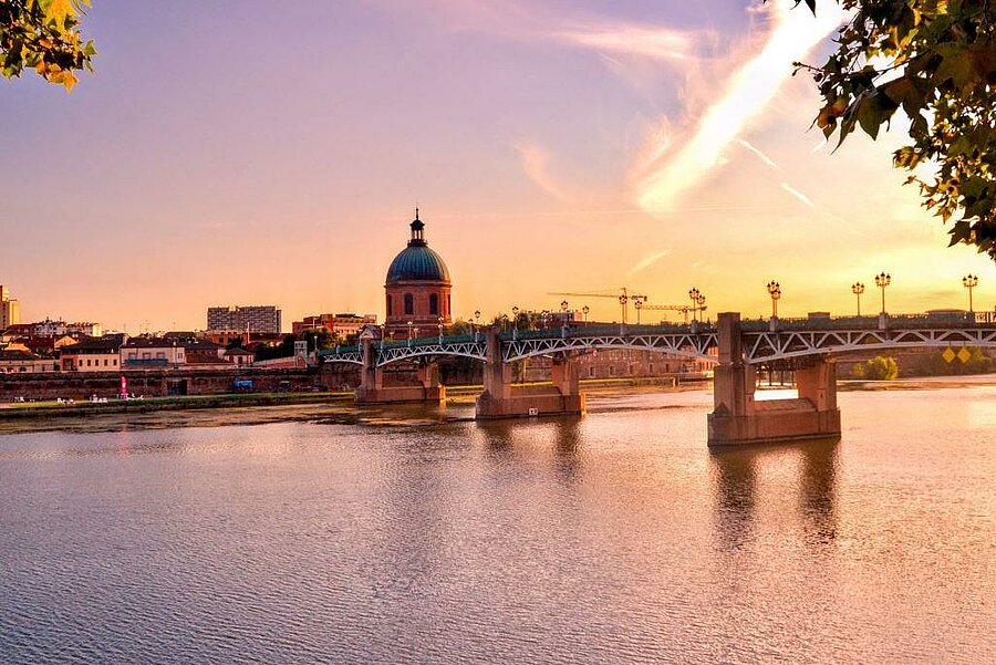 View of Saint-Pierre bridge and La Grave dome at sunset in Toulouse, seen from riverside near the campsite.