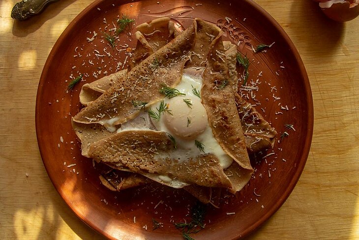 Buckwheat Breton galette topped with a free-range egg, a must-try speciality during a foodie stay near Plomeur.