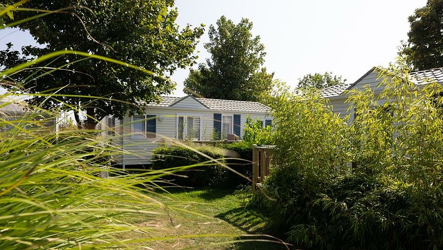 Modern mobile home surrounded by greenery in a Baie de Somme campsite, perfect for a comfortable family holiday.