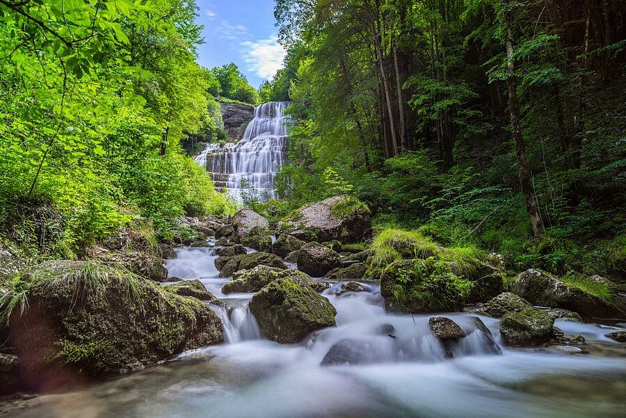 View of the Hérisson waterfalls surrounded by forest — an iconic natural site to explore during a campsite stay in the Jura.
