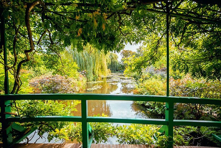 Green bridge over the water lily pond in Monet’s gardens in Giverny, Normandy, a romantic walk in the heart of an Impressionist setting.