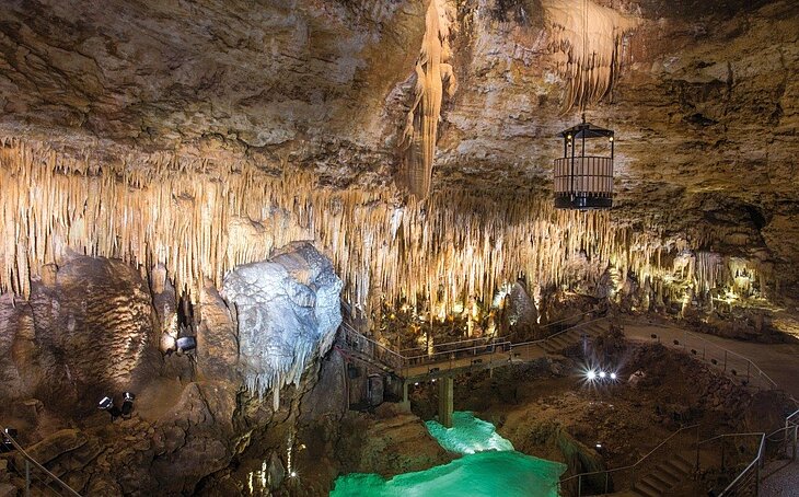 Gouffre de Proumeyssac © Jacques Sierpinski Interior of the Gouffre de Proumeyssac, featuring stalactites, rock formations and a visitor walkway near Le Bugue.