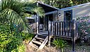 Modern mobile home with wooden terrace and lush greenery, ideal for a mobile home rental in a campsite in France.