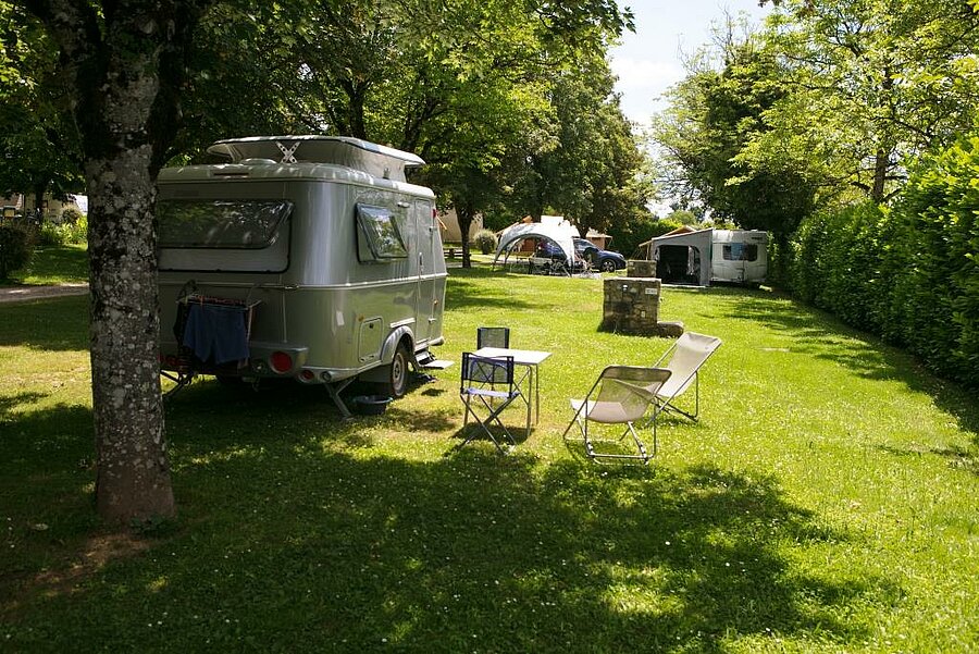 Spacious, shaded campsite pitch for caravans, available last minute in a lush natural setting.