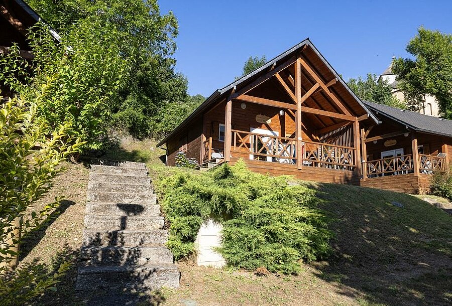 Comfortable wooden chalets on the hillside of a campsite, ideal for high-end camping holidays surrounded by nature.