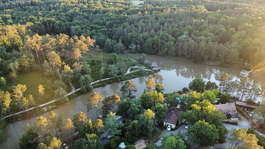 Aerial view of a campsite near Saint-Émilion with a lake and forest, a peaceful setting for Camping Saint-Émilion holidays.