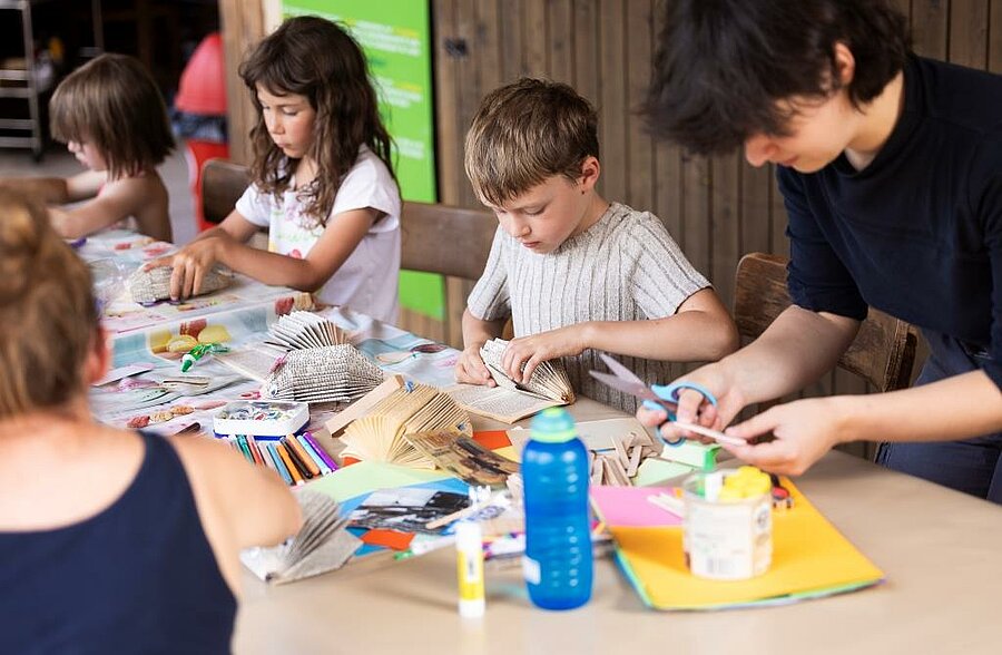 Children doing creative crafts at a campsite kids club, fun and supervised activities for all ages.