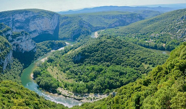 Panoramic view of the Gorges of the Ardèche, an iconic natural site in Auvergne-Rhône-Alpes, ideal for canyoning and hiking through breathtaking scenery