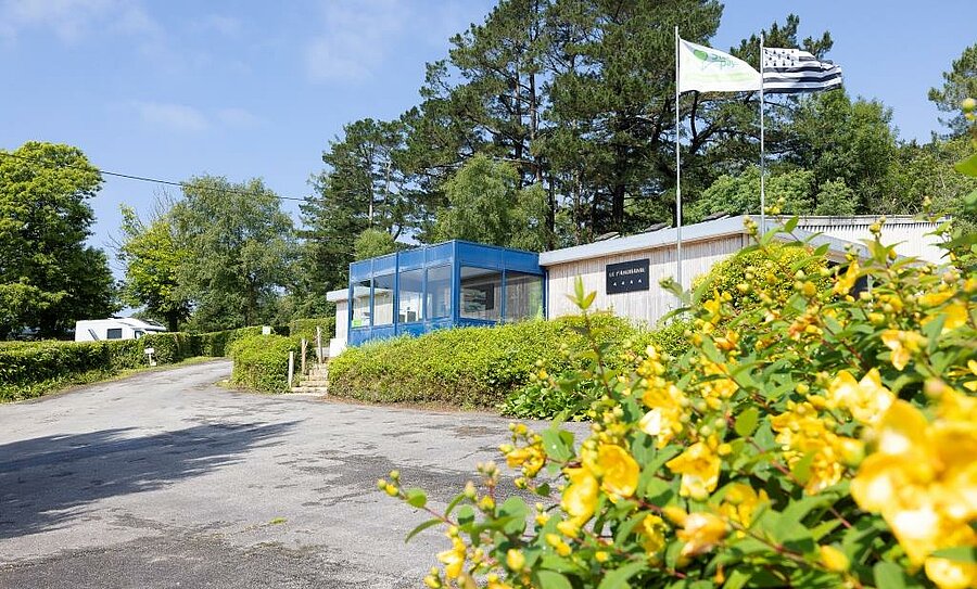 Flower-filled reception of a campsite in Finistère, with the Breton flag proudly waving in the wind, perfect for a nature holiday in Brittany.