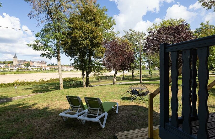 Terrace and deckchairs of a mobile home facing the Loire and Gien, in a peaceful, nature-filled setting for families.