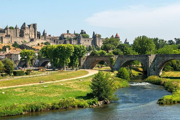 View of the medieval city of Carcassonne and the old bridge over the Aude, an unmissable stop nearby during a tourism getaway in Lézignan-Corbières.