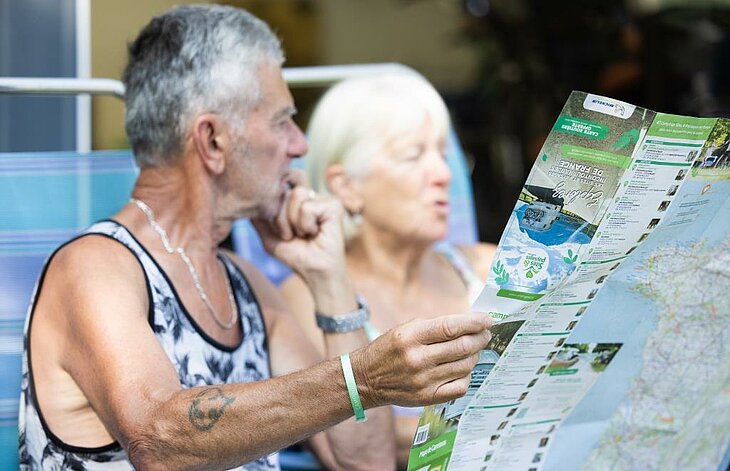 Prepare for your off-season campsite stay Couple looking at a tourist map to plan places to visit during their campsite stay.
