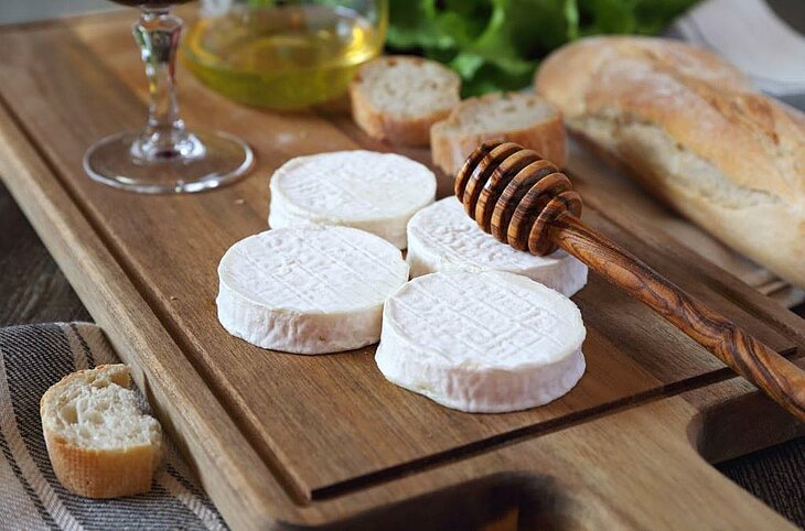 Rocamadour AOP cheeses served with bread and honey, a delicious local treat to try near Loupiac at a farmers' market.