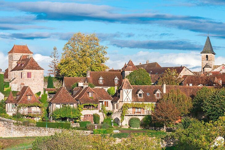 Traditional stone houses with tiled roofs in the village of Autoire, one of the most beautiful villages to visit near Thégra for an authentic tourism experience in the Lot.