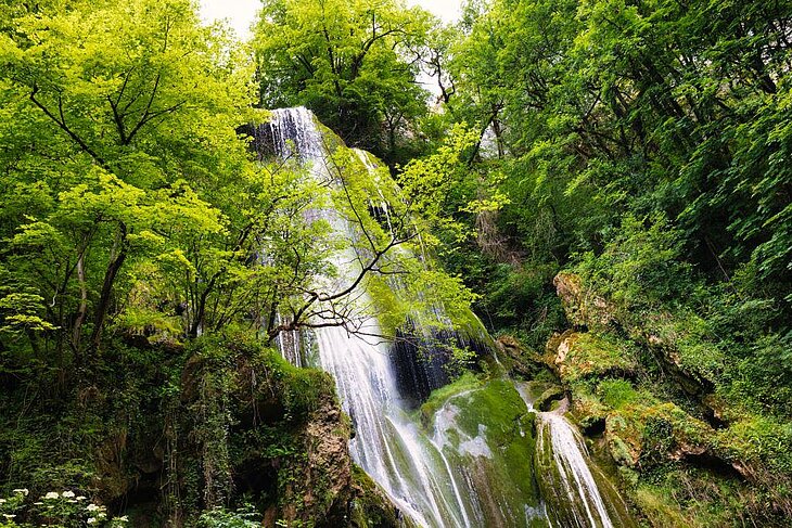 Autoire waterfall surrounded by lush greenery, a must-do hike around Thégra for nature lovers and sustainable tourism enthusiasts in the Lot.