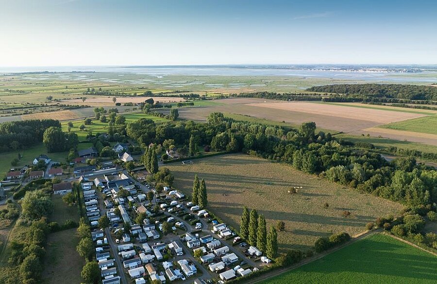 Aerial view of a campsite in the Baie de Somme, surrounded by fields and marshes, perfect for family holidays by the water.