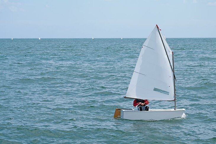 Young sailor in an Optimist, a perfect watersport for learning to sail in South Finistère.