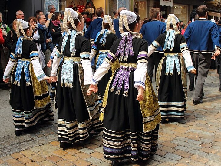 Parade in traditional Breton costumes at a cultural festival near Plomeur, a vibrant glimpse into the local identity of the Pays Bigouden